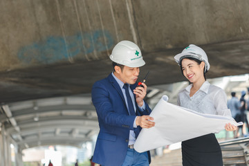 Man and women engineers with  blueprint blank plan as for construction.