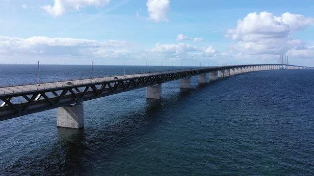 Commuter concept, traveling along a long bridge by car and train between Sweden and Denmark