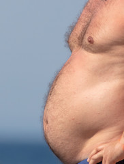 Fototapeta premium Big belly of a fat man on the beach