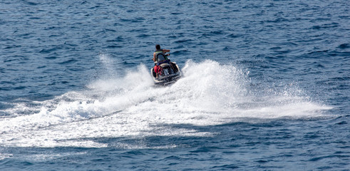 A motorcycle is racing in the blue water of the sea