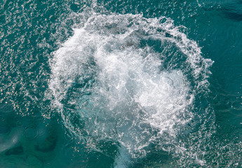 Fototapeta na wymiar Spray in the blue water of the sea