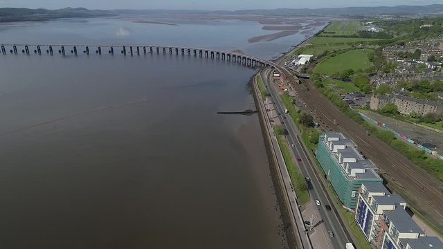 High level drone footage of Dundee waterfront flying towards River Tay rail bridge on beautiful sunny day.