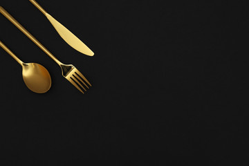 Luxury gold cutlery on black background, top view with space for text