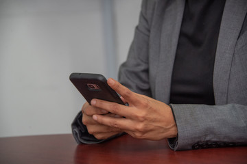 manos de mujer morena trabajadora con telefono celular y laptop azul en oficina