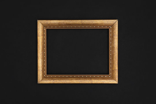 Gold painted frame on black background, top view with space for text