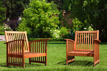 Fototapeta premium Wooden armchairs in beautiful garden on sunny day