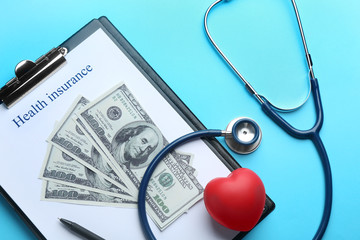 Flat lay composition with medical insurance form, money, heart and stethoscope on blue background