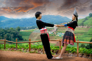 Couple holding hands in strawberry field on hill. Hand in hand, hand giving a helping hand.