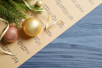 Flat lay composition with Christmas decorations and music sheets on blue wooden table. Space for...