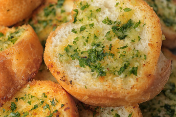 Slices of toasted bread with garlic and herbs as background, closeup