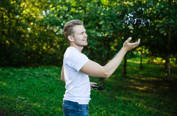 The young man manipulates the drone using the control panel. New technologies and trends in photo and video recording. record footage in the air.