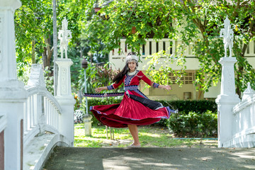 Naklejka premium Young woman dancing and spinning in a curvy traditional dress. Beautiful Hmong girl spins the skirt.