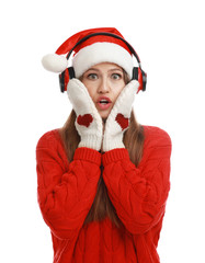 Fototapeta na wymiar Young woman in Santa hat listening to Christmas music on white background