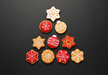 Christmas tree shape made of tasty homemade cookies on black background, flat lay