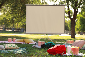 Empty open air cinema with blankets, pillows and popcorn. Space for text