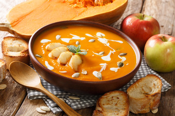 Homemade spicy hot pumpkin and apple soup with seeds close-up in a bowl. horizontal