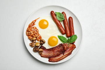 Traditional English breakfast with fried eggs on white table, top view
