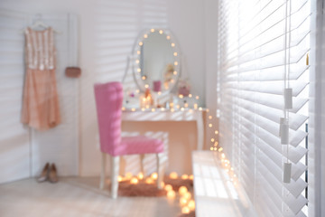 Naklejka na ściany i meble Blurred view of stylish room with dressing table and pink chair