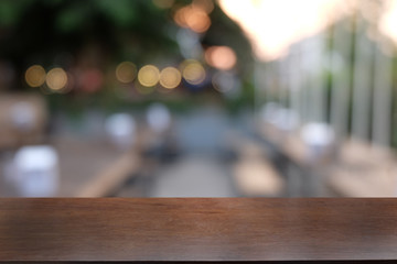 Empty dark wooden table in front of abstract blurred bokeh background of restaurant . can be used for display or montage your products.Mock up for space.