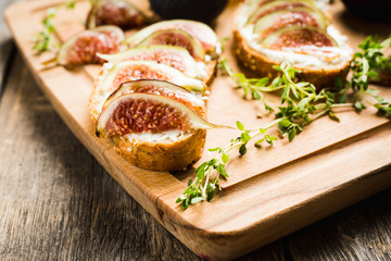 Sandwich with figs, cheese, honey and thyme. Selective focus. Shallow depth of field.