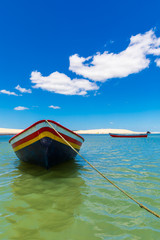 Colorful small boat anchored on a beach in Jericoacoara, Brazil