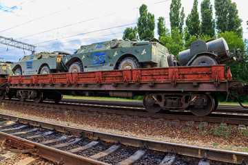 Obraz premium Cargo train carrying military vehicles on railway flat wagons