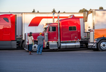 Truck drivers exchange views on the strengths and weaknesses of their big rigs semi trucks standing...