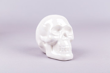 White shiny ceramic skull figures on a blank background