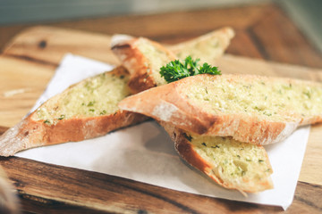 Close up Freshly baked garlic bread on wood plate.