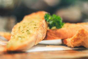 Close up Freshly baked garlic bread on wood plate.