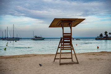 gazebo rescue service on a deserted evening sandy beach on a background of yachts and a cloudy sky