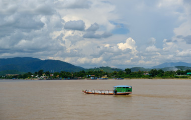 Fototapeta premium White clouds with a blue sky,Long tail boat moored at the MEKHONG River