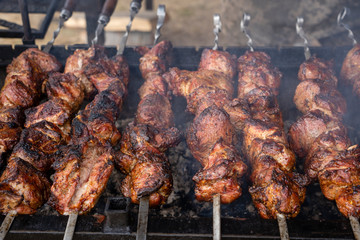 Grilled kebab cooking on metal skewer closeup. Roasted meat cooked at barbecue. BBQ fresh beef meat chop slices. Traditional eastern dish, shish kebab