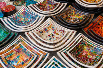 Colorful mosaic decorative plates on the market for sale on local street market in Ubud, island...