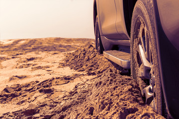 Car wheels on a sea beach sand. Close-up of car wheel on sandy dunes. Car stuck in the sand....