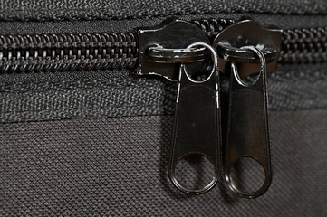 Black zipper handles on a black suitcase. © lapis2380