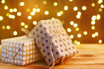 Festive gift box on wooden table against brown bokeh background