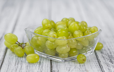 Wooden table with White Grapes (detailed close-up shot; selective focus)