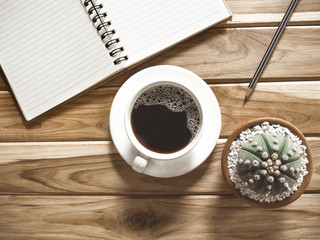 Coffee notebooks and cactus on a wooden table