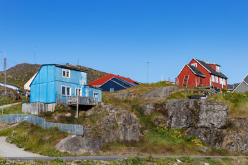 Fototapeta na wymiar View of wooden colored houses on rocky hills in Qaqortoq, Greenland.