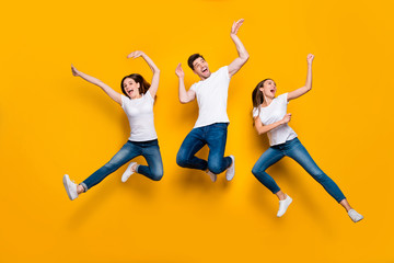 Fototapeta na wymiar Full length body size view portrait of three nice attractive charming slim sporty cheerful cheery ecstatic person buddy fellow having fun isolated over bright vivid shine yellow background