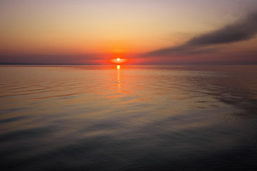 Beautiful colorful sunset on the sea coast. Nice scene with sunrise over water