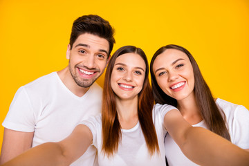 Self-portrait of three nice attractive lovely winsome charming caucasian cheerful cheery positive person having fun isolated over bright vivid shine yellow background