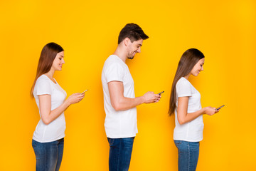 Profile side view portrait of three nice attractive lovely focused cheerful cheery person using wi-fi connection speed browsing web isolated over bright vivid shine yellow background