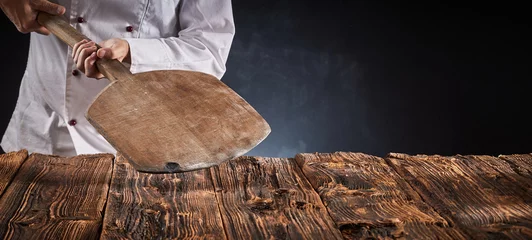 Wandaufkleber Chef holding an empty wooden pizza paddle © exclusive-design