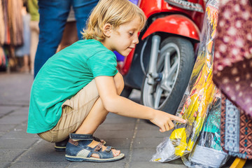Boy at a market in Ubud, Bali. Typical souvenir shop selling souvenirs and handicrafts of Bali at the famous Ubud Market, Indonesia. Balinese market. Souvenirs of wood and crafts of local residents