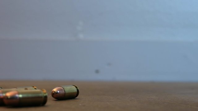 Dangerous large caliber ammo rolling on the table right to left