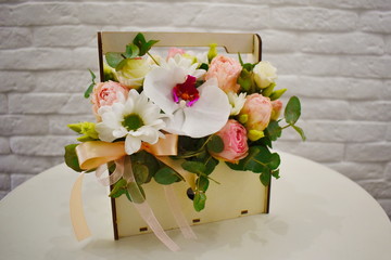 Flower arrangement in a hat box on the table.