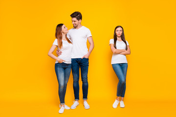 Full size phot of sullen girl looking at sweethearts cuddling wearing white t-shirts denim jeans...