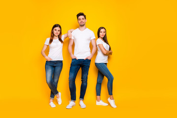 Full size photo of cool hipster with long hair folding their hands wearing white t-shirt denim jeans isolated over yellow background